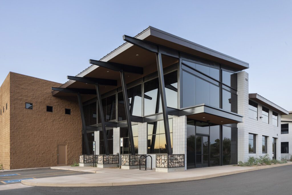 Modern commercial building in DC Ranch, Scottsdale with large glass windows and distinctive angular roof design.
