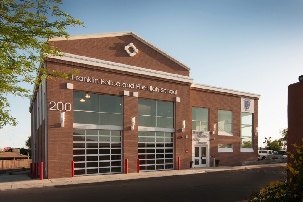 A modern brick building housing Franklin Police and Fire Academy with large windows and a fire station-style rolling door now includes a Classroom Building Addition.