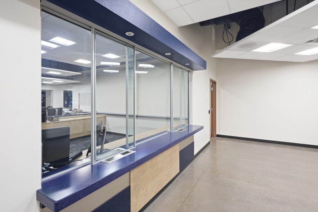 Modern office reception area with glass partition, counter, and lobby security upgrades.